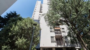 A multi-story residential building with balconies, surrounded by trees. - Skyline View - Design Apartment - Bicocca Metro (Milano)