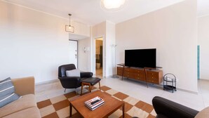 A modern living room with a sofa, a coffee table, a television, and a cabinet. - Skyline View - Design Apartment - Bicocca Metro (Milano)