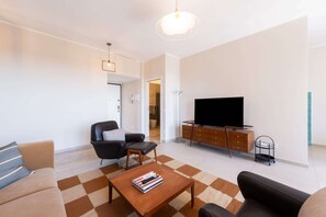 Ein modernes Wohnzimmer mit einer Couch, einem Couchtisch, einem Fernseher und einem Schrank.
