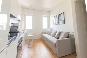 Eine moderne Küche mit Einbauherd und einem Essbereich mit weißem Tisch und Stühlen.