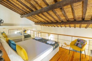 A room with a bed, a chair, a balcony, and a wooden ceiling. - Monti - Stunning Loft in the Heart of Rome's Monti (Rome)