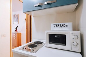 A kitchen with a microwave oven, a bread sign, and a small stove. - Appartamento vista Matterhorn (Breuil-Cervinia)