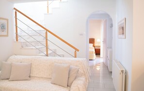 Ein Schlafzimmer mit einem Bett, Kissen, einer Treppe und einem Flur, der zu einem Badezimmer führt.