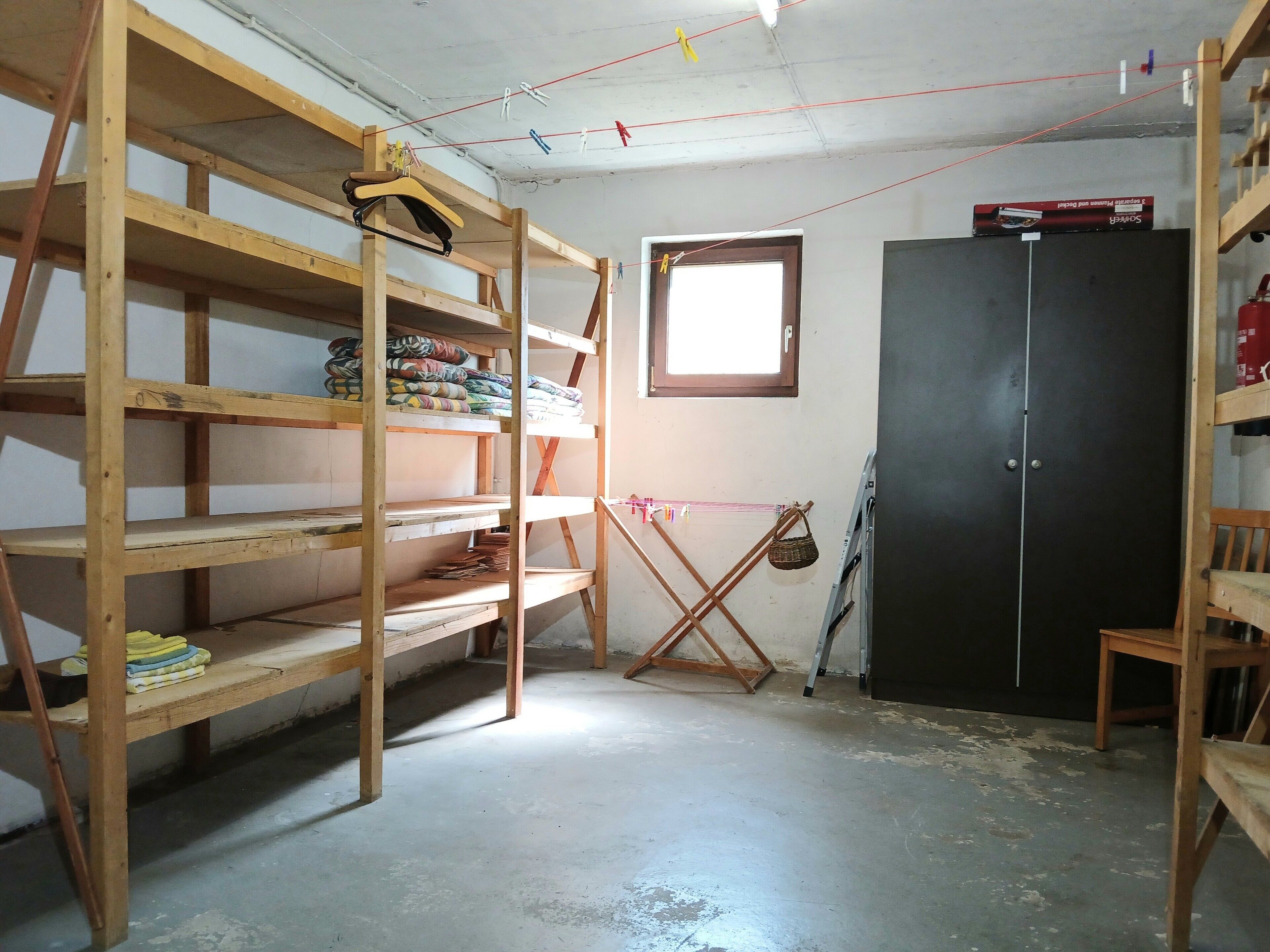 Ein Zimmer mit Holzbögen, einem Kleiderschrank und einem Fenster.