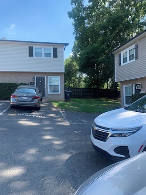 A residential street with two-story houses, a parking area, and a driveway. - Better Days (Charlotte)