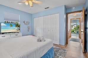 A bedroom with a bed, a television, a ceiling fan, and a wardrobe. - Sunshine Daydream in Anna Maria Island (Holmes Beach)