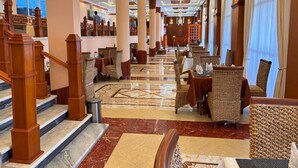 A hotel lobby with a grand staircase, high ceilings, and a mix of seating areas. - 2RN Solomon Hotel (Sendafa)