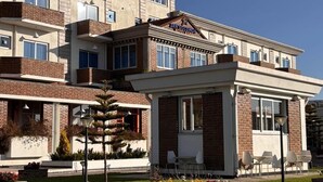 A multi-story building with a flat roof, a brick facade, and a small attached structure with a white exterior. - 2RN Solomon Hotel (Sendafa)