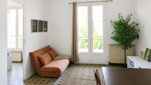 A room with a brown sofa, a ceiling fan, a plant, and a window with curtains. - Cozy & bright 2-bedroom apartment - Avignon - 700 m from the city walls (Avignon)