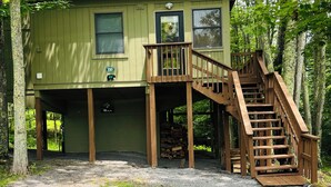 A two-story wooden cabin with a wooden staircase leading to the upper level. - Cozy cabin in Davis, WV 
Hibernation Station - Black Bear Resort (Davis)