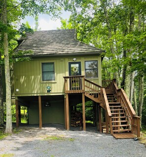 A two-story wooden cabin with a wooden staircase leading to the upper level. - Cozy cabin in Davis, WV 
Hibernation Station - Black Bear Resort (Davis)