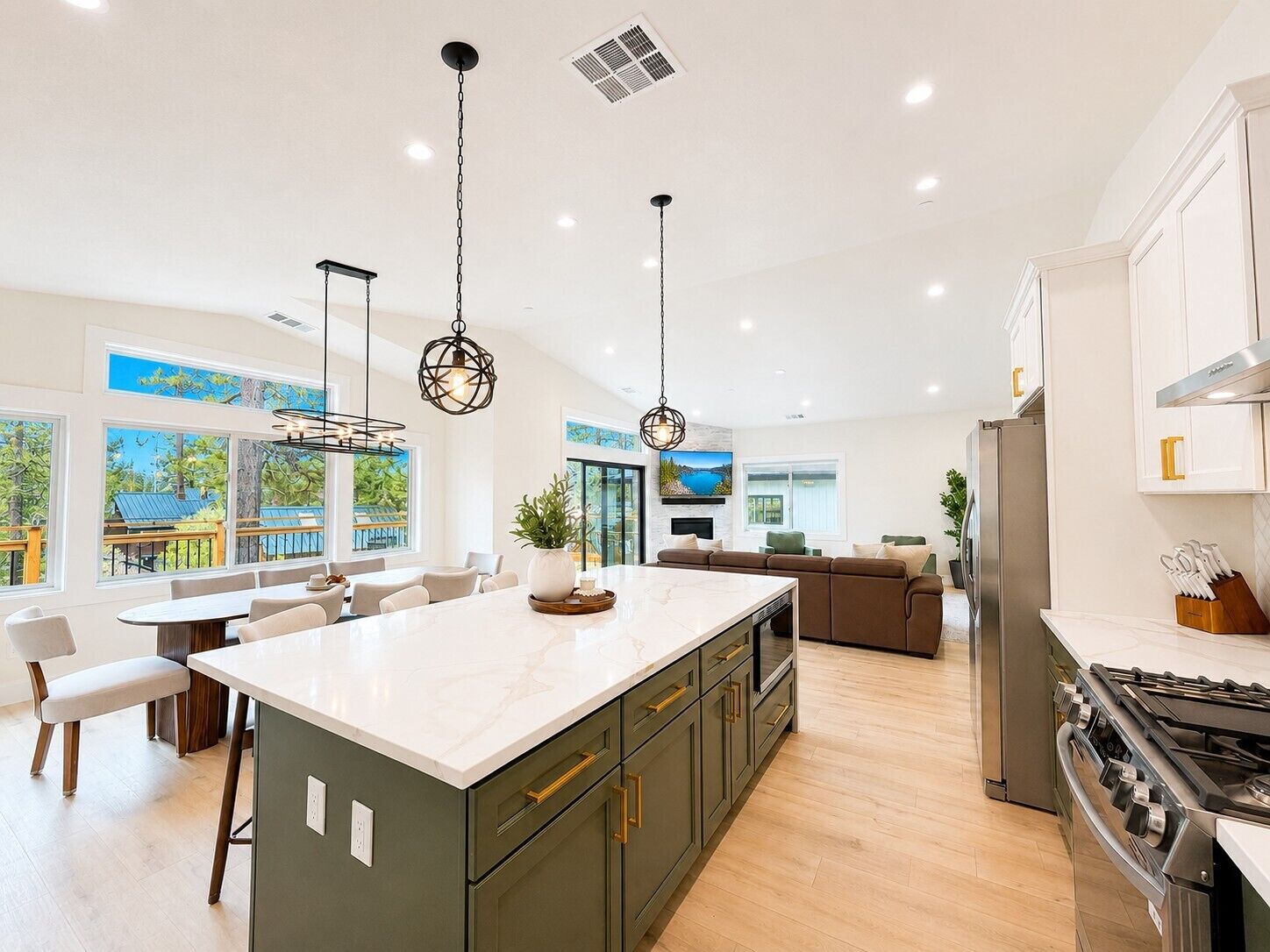 A modern kitchen with a large island, built-in appliances, and ample natural light from large windows.