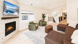 A spacious living room with a fireplace, a large TV, and a cozy seating area. - South Lake Tahoe Home Near Heavenly, Edgewood Golf & beaches (SLT1040) (South Lake Tahoe)