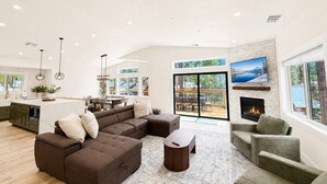 A spacious living room with a sectional sofa, a fireplace, and a large window overlooking a deck. - South Lake Tahoe Home Near Heavenly, Edgewood Golf & beaches (SLT1040) (South Lake Tahoe)