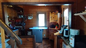 Un intérieur en bois comprenant un coin cuisine, un évier et un réfrigérateur.