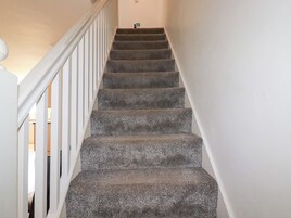 A staircase with carpeted steps and white railings.