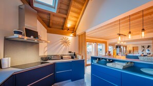Una cucina moderna con travi in legno, un'isola grande e vista all'esterno.