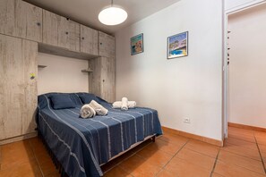 A bedroom with a bed, a wardrobe, and two framed pictures on the wall. - Le Cocody - Appt avec terrasse, proche de la plage (Lumio)