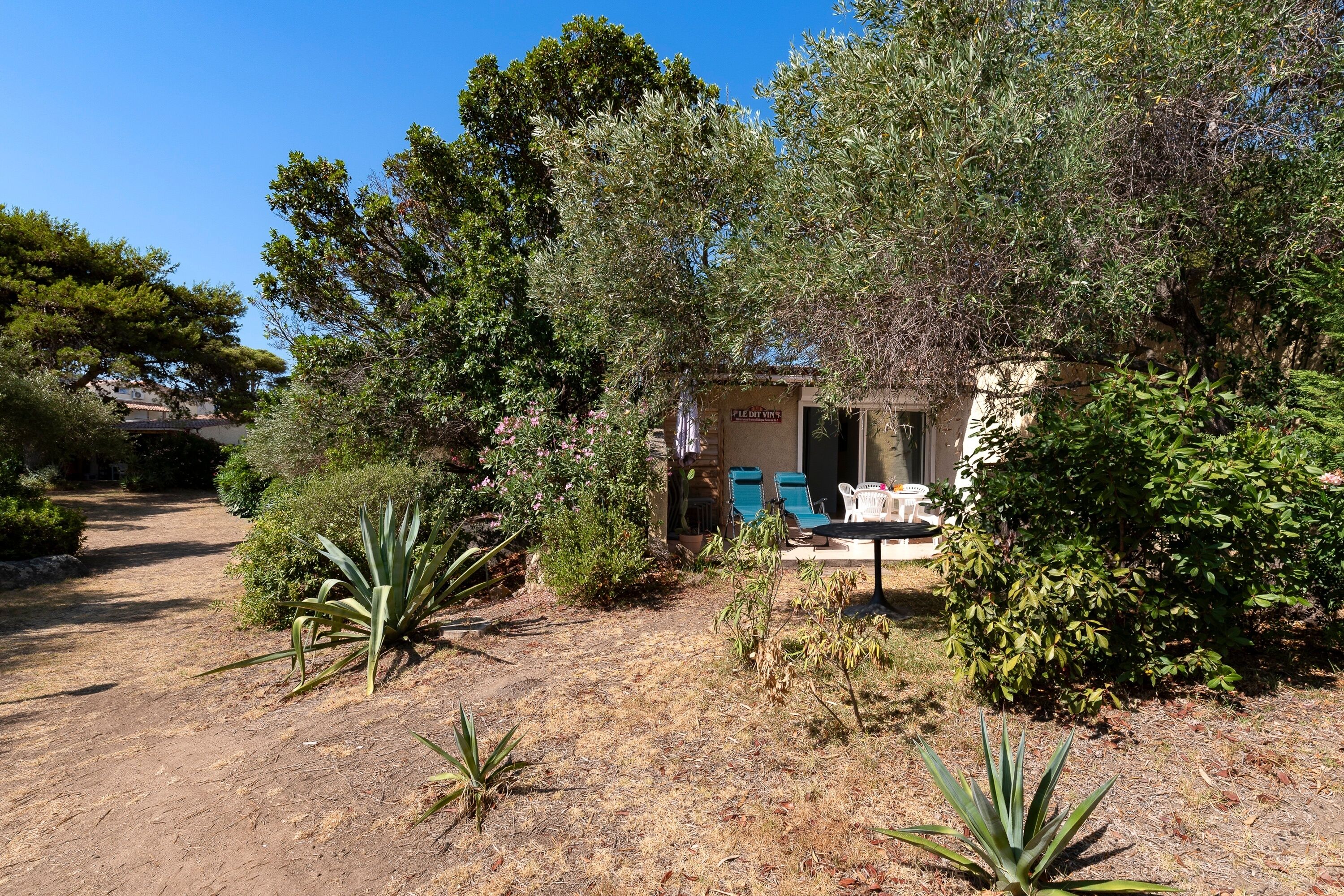 A garden with a patio, a small building labeled 'PLEDGE VIEW,' and a dirt path.