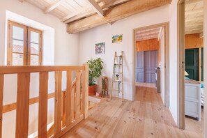 Ein Holzinnenraum mit Treppe, einer Topfpflanze und einer Leiter.