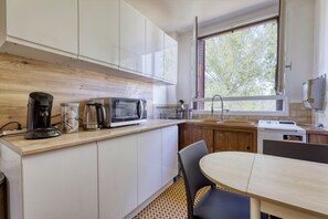 A compact kitchen with a microwave, coffee maker, and a small sink. - Louis Choix - À 1 km de la gare Garges (Garges-les-Gonesse)