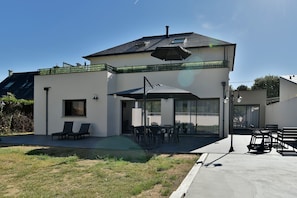 A modern two-story house with a patio, outdoor seating, and a covered area. - Ti Kastrilhez - 1er - À 1 km de la plage (Saint-Cast-le-Guildo)