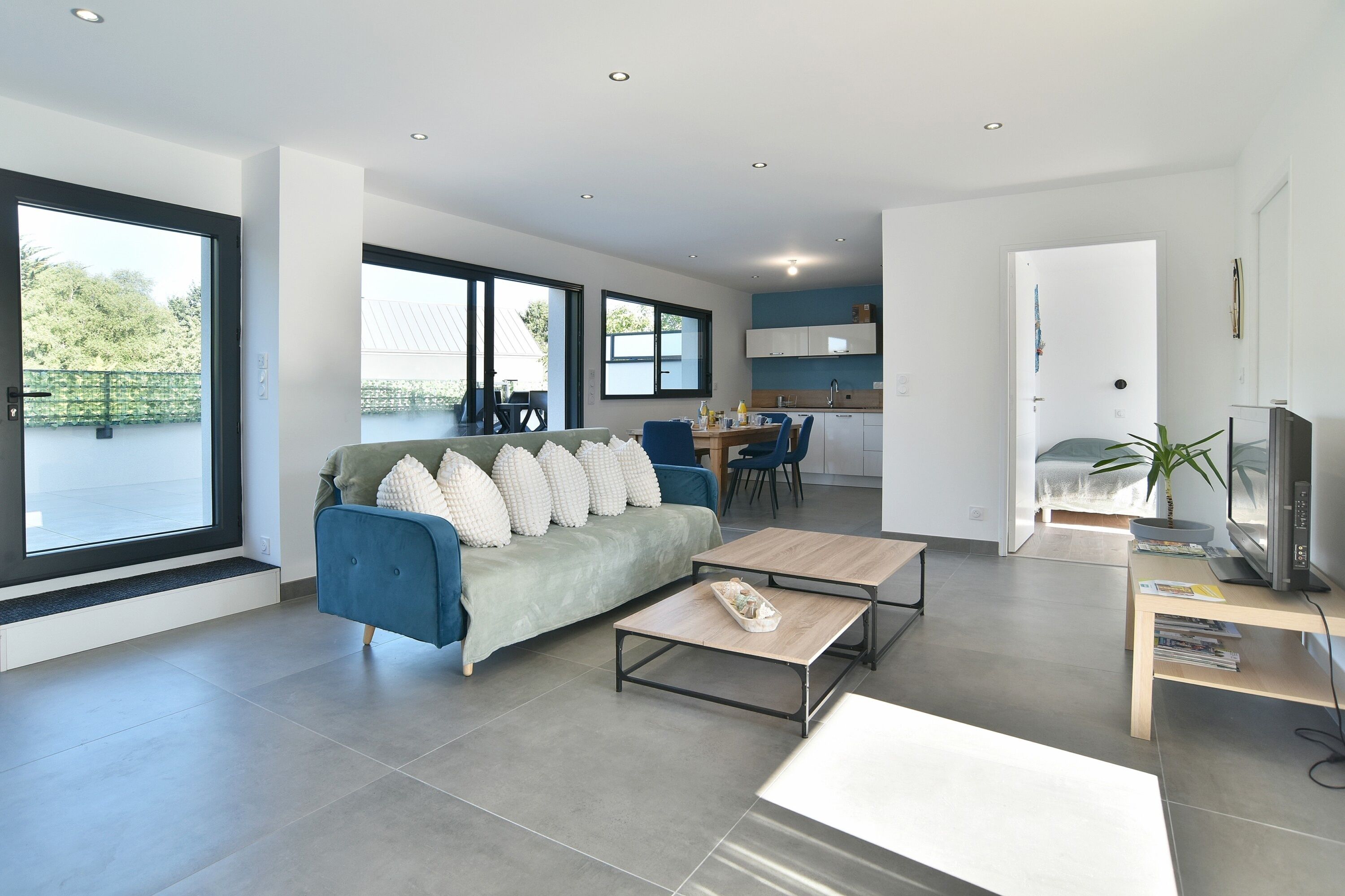 A modern living room with a sofa, coffee table, and TV stand.