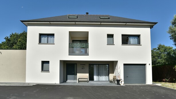 A two-story building with a flat roof, a balcony, a garage, and a bench outside. - Ti Kastrilhez - 1er - À 1 km de la plage (Saint-Cast-le-Guildo)