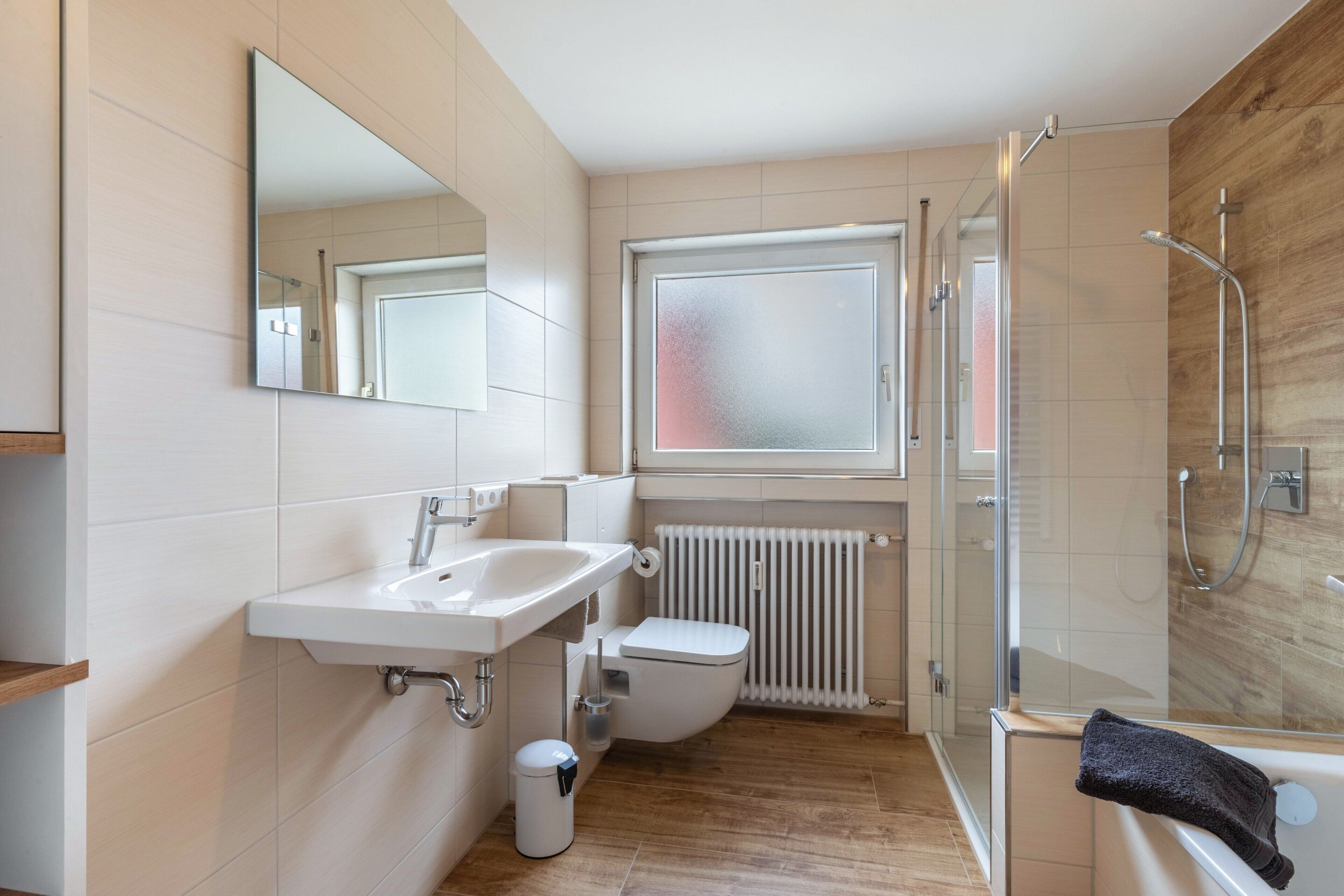 Un baño moderno con lavamanos, inodoro y ducha.