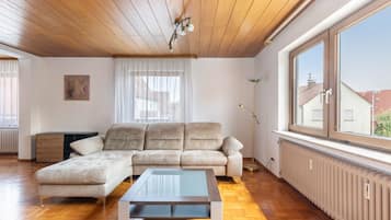 A spacious living room with a large sectional sofa, a glass coffee table, and a floor lamp.