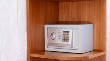 A white safe with a keypad and a lock, placed on a wooden shelf.