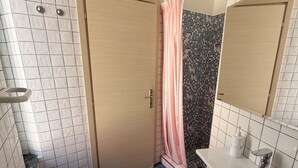 A bathroom with a toilet, bidet, sink, and a shower area with a curtain. - CASA al centro di Lacco Ameno: a piedi alle terme Negombo, mare e ristoranti (Lacco Ameno)
