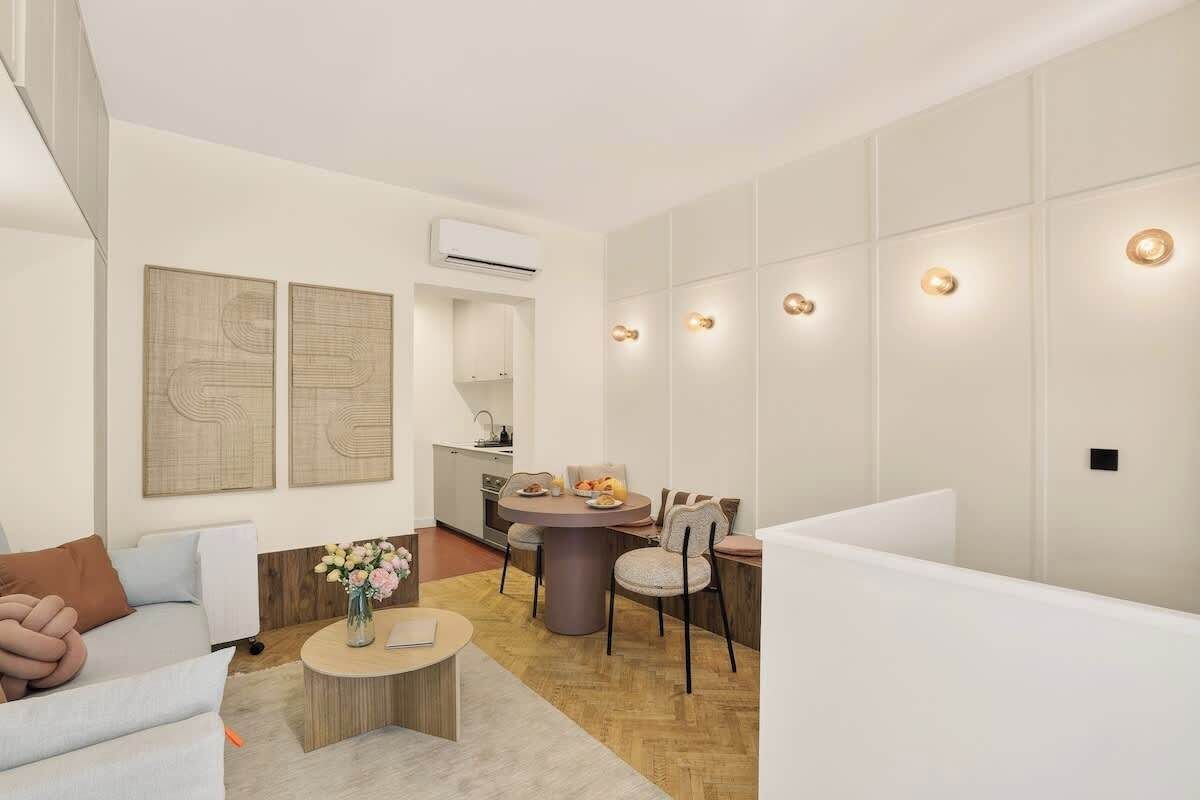 A modern living room with a sofa, coffee table, and dining area.