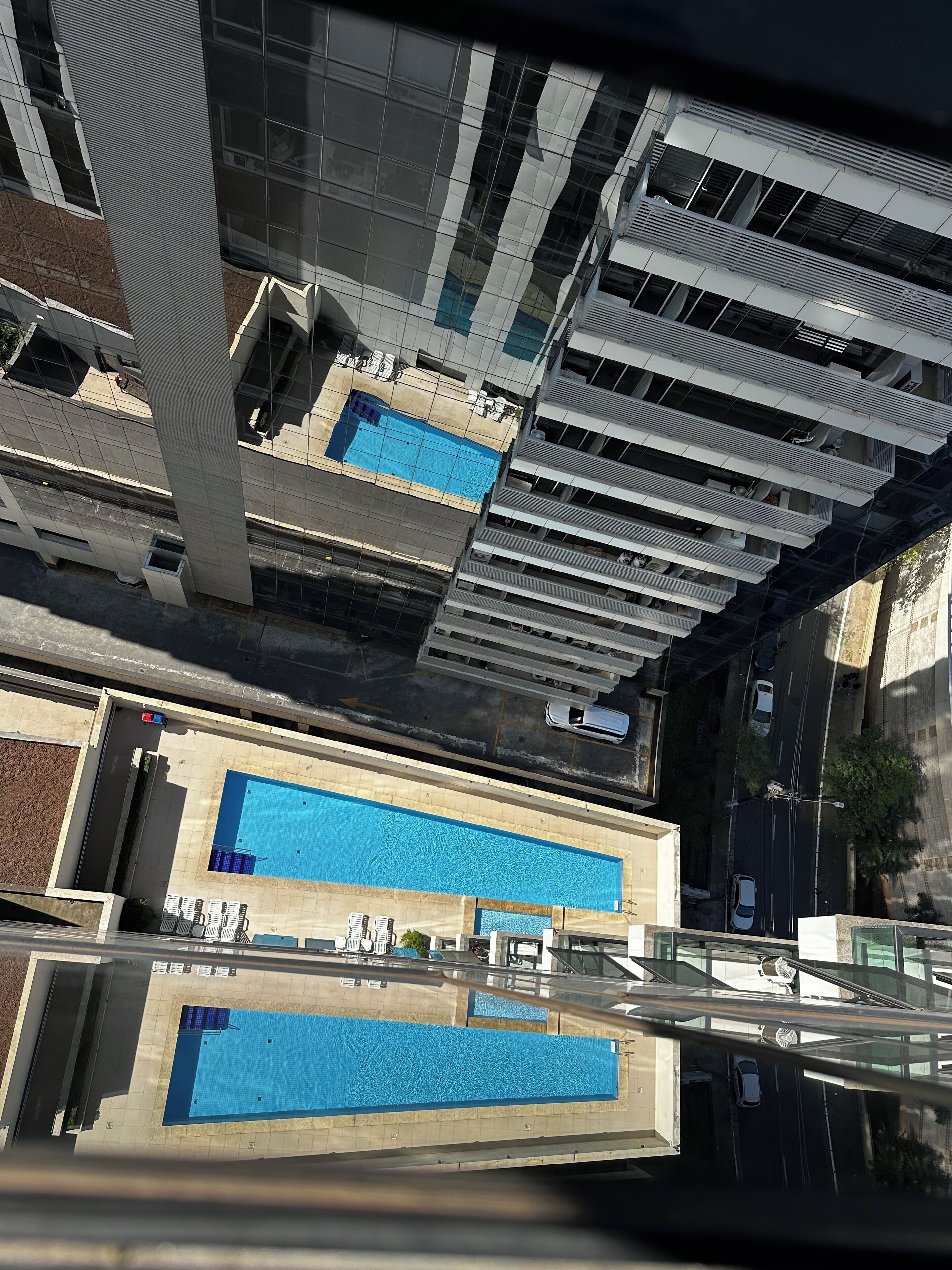 Un immeuble de grande hauteur doté d’une piscine sur le toit et de nombreux balcons.