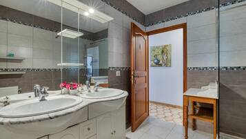 Ein Badezimmer mit zwei Waschbecken, einem Spiegel und einer Holztür.