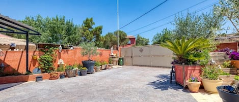 A courtyard with a flag, potted plants, and a tiled floor.