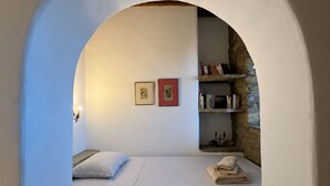 Une pièce confortable avec un lit intégré, une petite étagère remplie de livres et un tableau encadré accroché au mur.