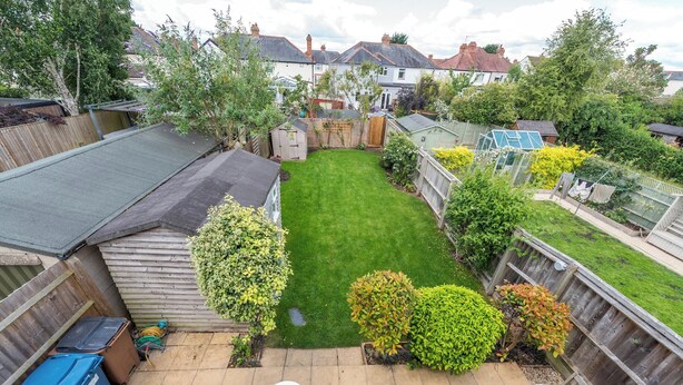 A residential backyard with a lawn, a wooden fence, and a shed. - Cosy 3BR House with free parking (Oxford)