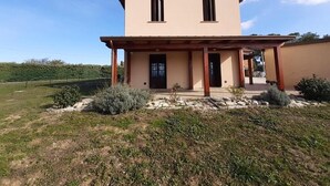 Ein zweigeschossiges Haus mit einer Veranda und einem Steinfundament.