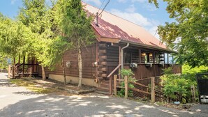 Eine rustikale Holzhütte mit Metalldach, Holzveranda und einer kleinen Treppe zum Eingang.