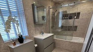 Een moderne badkamer met toilet, wastafel en douche.