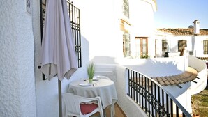 A white building with a balcony, a table with a white tablecloth, a chair, and a potted plant. - Ap1139 in Denia With 1 Bedrooms and 1 Bathrooms (Denia)