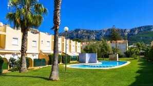 Ein Resort mit Swimmingpool, Palmen und Bergblick.