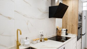 A modern kitchen with a double sink, stainless steel faucet, and a built-in oven. - Ad1360 in Oliva With 3 Bedrooms and 1 Bathrooms (Oliva)