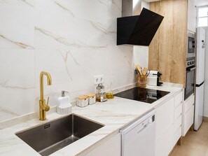 A modern kitchen with a double sink, stainless steel faucet, and a built-in oven. - Ad1360 in Oliva With 3 Bedrooms and 1 Bathrooms (Oliva)