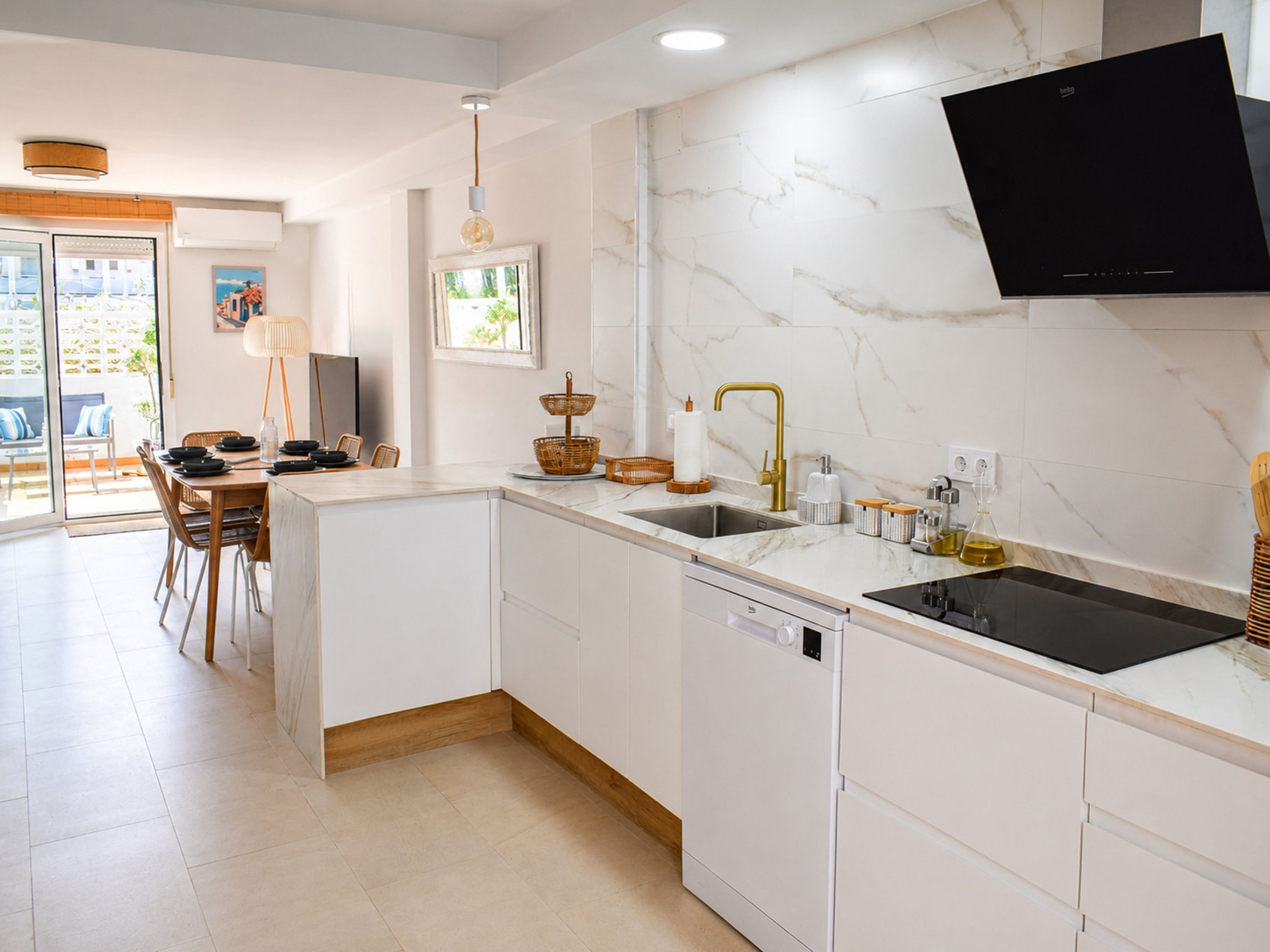 A modern kitchen with white cabinetry, a built-in dishwasher, a black stove, and a large window.