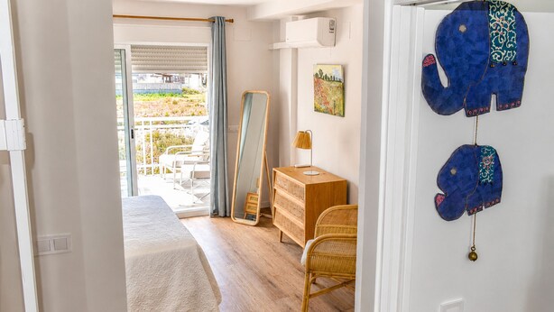 A bedroom with a bed, a dresser, a mirror, and a view of the outside. - Ad1360 in Oliva With 3 Bedrooms and 1 Bathrooms (Oliva)