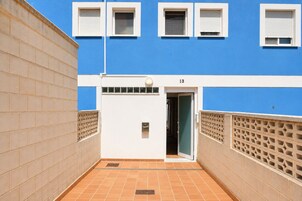 Un edificio con fachada azul, detalles blancos y el número 13.