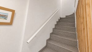 A staircase with a handrail, a framed picture on the wall, and a wooden panel on the right. - Ad1360 in Oliva With 3 Bedrooms and 1 Bathrooms (Oliva)