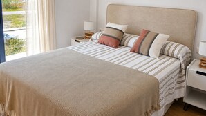 A bedroom with a bed, pillows, a bedside table, a lamp, and a view of the outdoors. - Ad1360 in Oliva With 3 Bedrooms and 1 Bathrooms (Oliva)